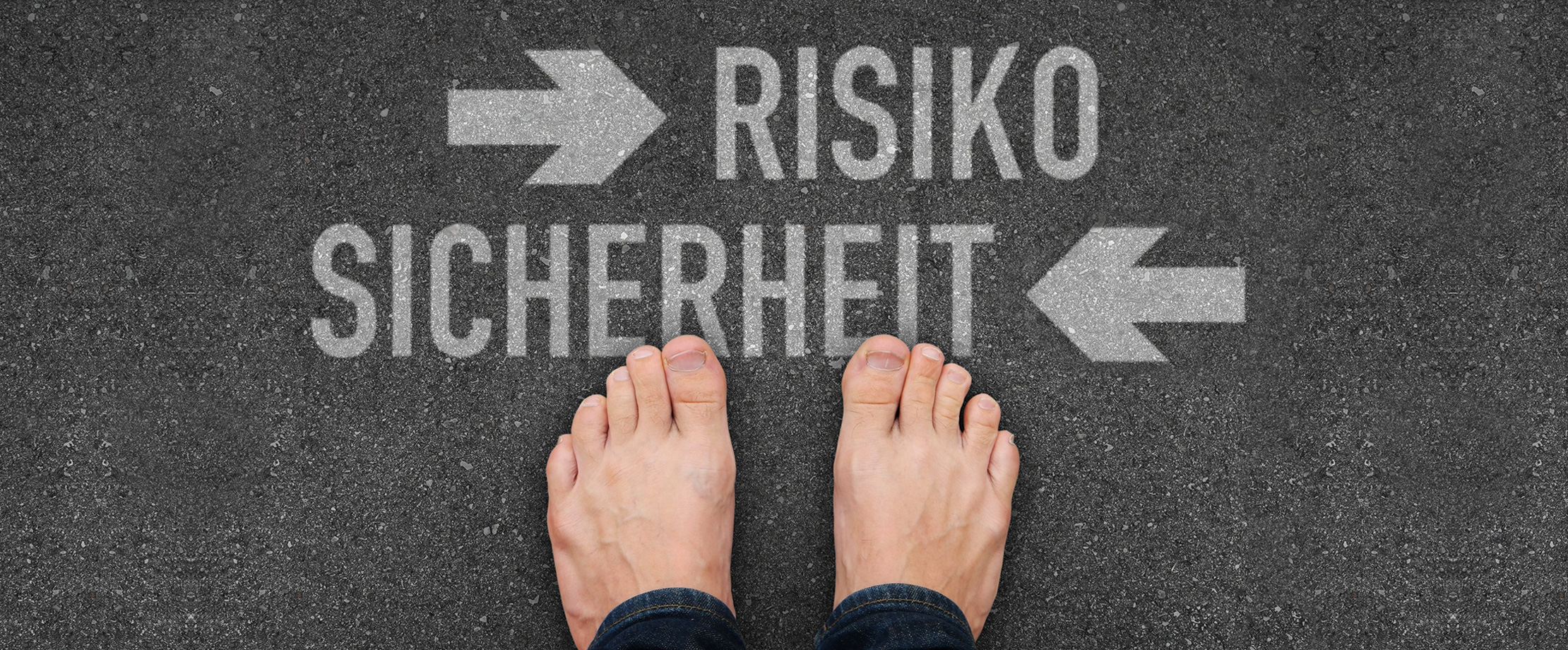 Jemand steht barfuß auf Asphalt. Vor den Füßen der Person ist mit Kreide „Risiko“ und ein Pfeil nach rechts sowie „Sicherheit“ und ein Pfeil nach links abgebildet.